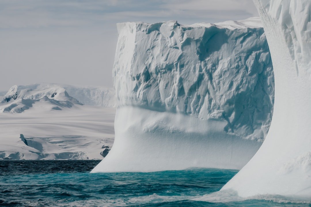 Luxury expedition cruise ship surrounded by glaciers representing exclusive consortia hosted sailing perks